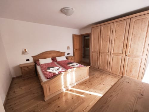 Spacious bedroom in Udai Apartment, Residence Rodolon, Mazzin with wooden furnishings, double bed, and mountain views