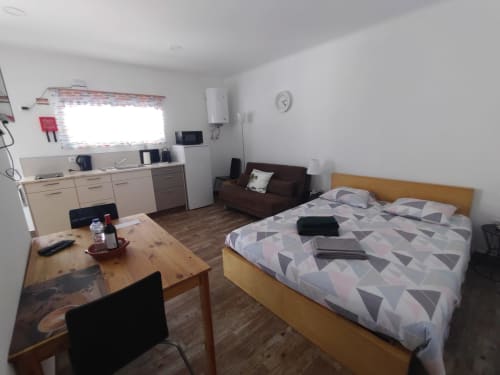 Estúdio espaçoso na Casa do Pão com cama, kitchenette, mesa de jantar e sofá marrom em Campinho