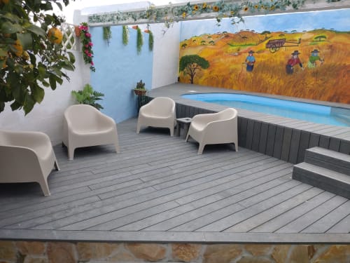 Terraço à beira da piscina da Casa do Pão com cadeiras brancas, piscina azul e mural de cena de colheita, Campinho