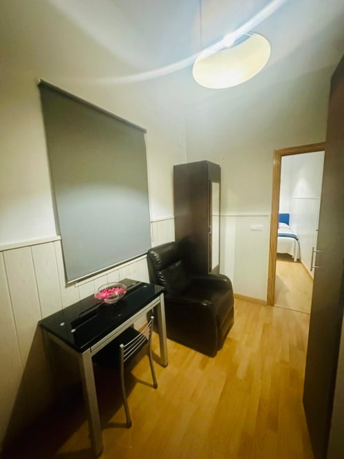 Apartamento moderno en Mérida con escritorio, silla negra, pizarra blanca y pisos de madera