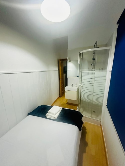 Moderno apartamento estudio en Mérida con cama, baño ensuite y paneles blancos