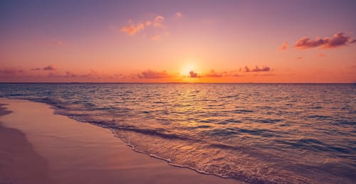 Coucher de soleil sur la Méditerranée à la plage de Cavalaire-sur-Mer avec ciel doré et vagues