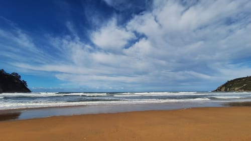 Plage de sable doré à Cavalaire-sur-Mer avec des vagues turquoise et un ciel bleu