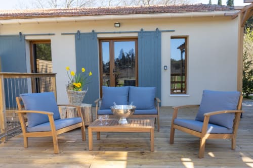 Terrasse ombragée avec salon de jardin et pergola, parfaite pour les apéritifs en fin de journée.