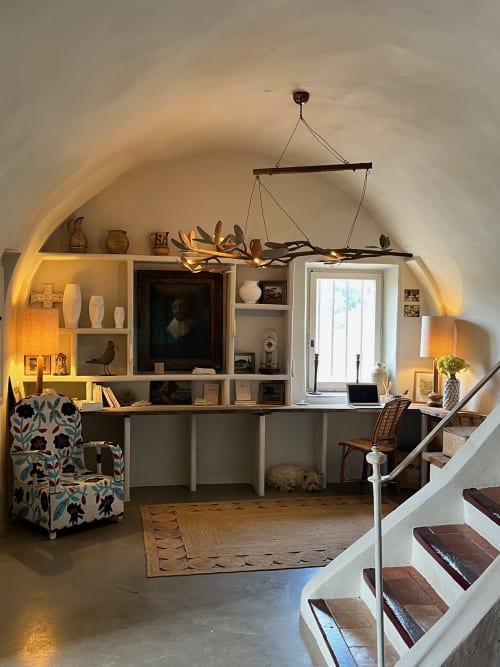 Elegant home office nook at Saint Martin B&B in Ollioules with arched ceiling, white shelving, and decorative lighting
