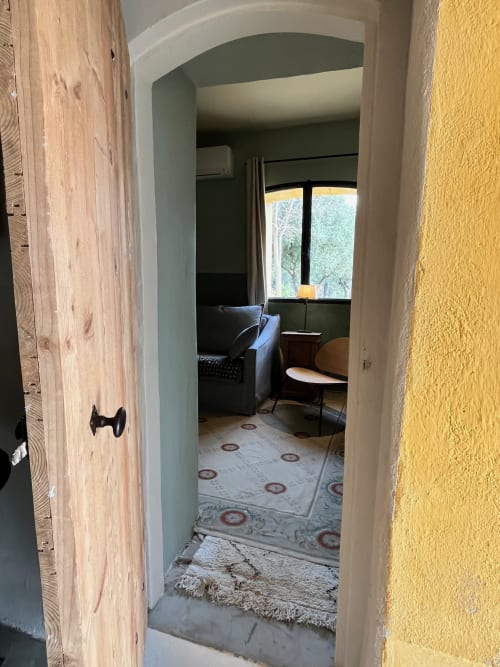Hallway entrance to bedroom at Saint Martin BnB in Ollioules, France, with wooden doors and warm interior décor