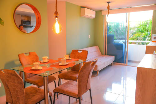Moderna habitación triple en Olamar Living de Coveñas con comedor, sofá, paredes coloridas y balcón con vista al jardín