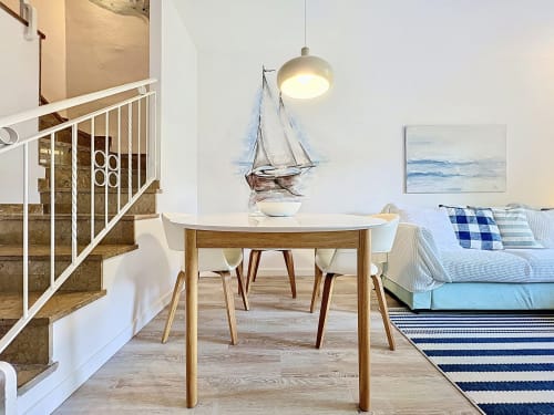 Luminoso salón abierto en la casa Mar Blau de Estartit Rental, con mesa de comedor redonda, decoración náutica y