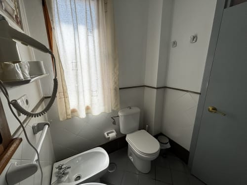 Baño clásico con lavabo y espejo en habitación twin de Hotel Entreolivos.