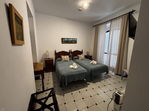 Habitación twin con camas individuales y ventanales en Hotel Entreolivos.