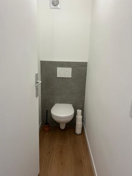 Toilettes modernes à la villa de Mazet Cavalaire, Cavalaire-sur-Mer avec mur d'accent en carrelage noir et accessoires blancs