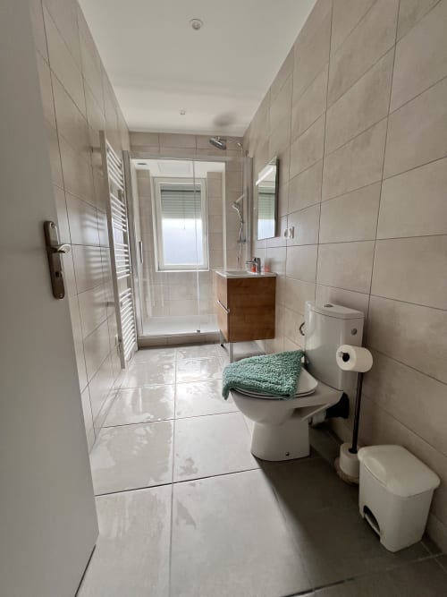 Salle de bain moderne du gîte Le Restaurant du Port, Saint Pierre de Boeuf, avec douche italienne et vue sur le lac