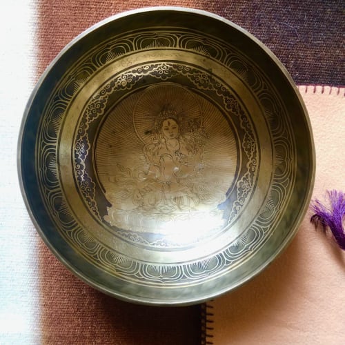 Ornate brass singing bowl with deity engraving at Domaine de l'Ocrerie, Pourrain
