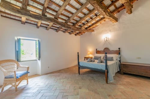 Chambre rustique avec poutres apparentes, carrelage en terre cuite et lit à baldaquin chez Finques Garcia Enrich, Palafrugell