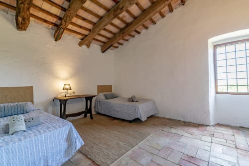 Chambre rustique avec poutres apparentes, deux lits et carrelage en terre cuite chez Finques Garcia Enrich, Palafrugell
