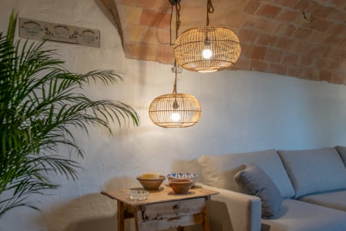 Coin salon accueillant à Finques Garcia Enrich avec luminaires en osier, canapé blanc, table d'appoint et plante en pot