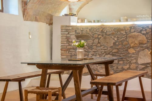 Salle à manger rustique avec table en bois et bancs à l'hôtel Finques Garcia Enrich à Palafrugell, murs en pierre