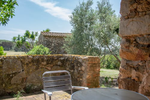 Terrasse en pierre rustique avec coin détente aux Finques Garcia Enrich, Palafrugell, vue sur les oliviers