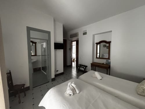 Habitación triple con camas y ventanales en Hotel Entreolivos.