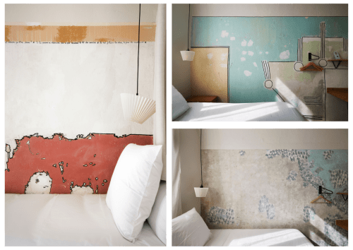 Chambre artistique à l'Hôtel La Prison Béziers avec murs patinés, tête de lit rouge et design minimaliste moderne