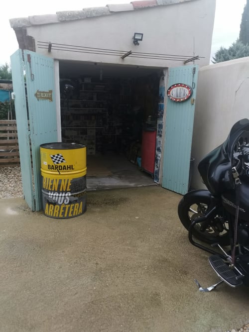 Atelier garage vintage au Cabanon du Clos B&B à L'Isle-sur-la-Sorgue avec moto et fûts d'huile