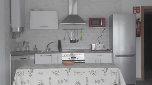 Cuisine moderne de la Casa Rural La Perla avec appareils en acier inoxydable, armoires blanches et comptoirs en marbre