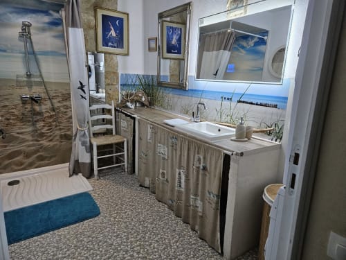 Strandthematisches Badezimmer im Manoir Lacustre mit Ozeanmalereien, Waschbecken, Spiegel und Küstendeko in Queyrac