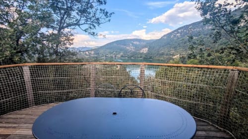 Bain à remous sur terrasse en bois avec vue sur le lac du Bourget et les montagnes boisées aux Cabanes et lodges du Belvédère, Serrières-sur-Ain