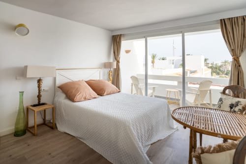 Dormitorio moderno en Formentera Especial con balcón vista al mar, muebles de madera y decoración costera