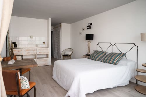Dormitorio moderno en Formentera Especial con cama de estructura metálica, almohadas a rayas, baño privado y decoración minimalista