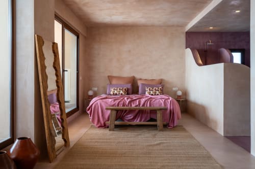 Dormitorio moderno en Formentera Especial con ropa de cama rosa, detalles de madera y paredes de terracota en La Savina