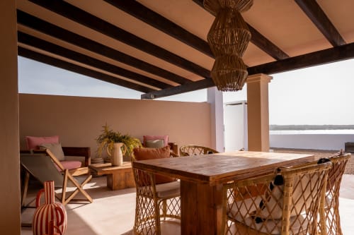 Terraza Formentera Especial con mesa de comedor de madera, sillas de mimbre y vistas al mar desde el balcón del apartamento La Savina