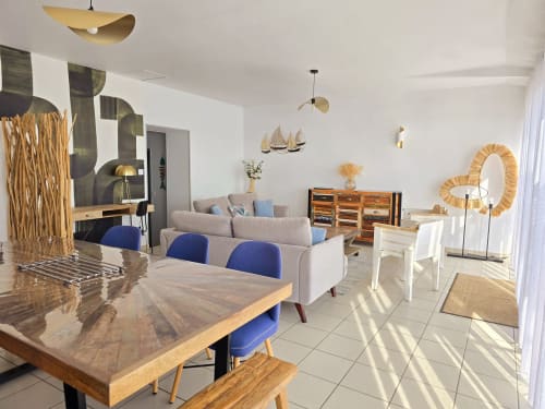Modern cottage dining and living area at Relais des Îles in Saint-Marcouf with sea views, wooden furnishings, and