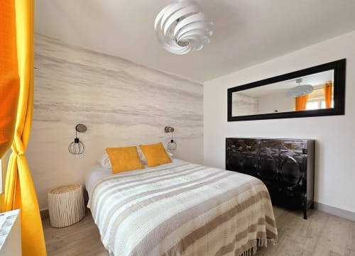 Modern bedroom at Relais des Îles cottage in Saint-Marcouf with queen bed, orange accents, and minimalist décor