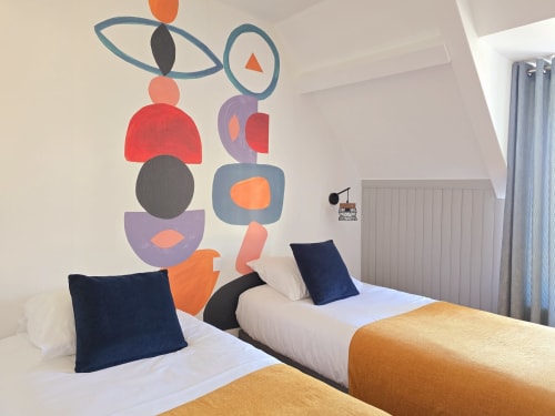 Modern bedroom at RELAIS DES ILES cottage with twin beds, navy pillows, and colorful geometric wall art in Saint-Marcouf