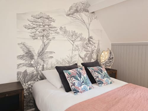 Elegant bedroom at Relais des Îles cottage with botanical wallpaper, white bedding, patterned pillows, and coastal décor in