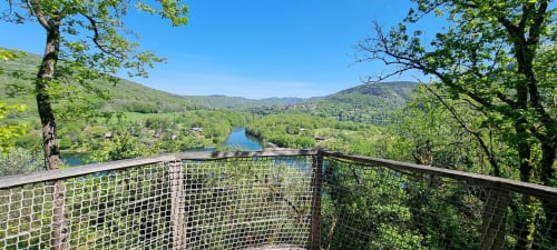 Panoramic view from deck at Cabanes du Belvédère showing Ain River through green valley and mountains, Serrières-sur-Ain