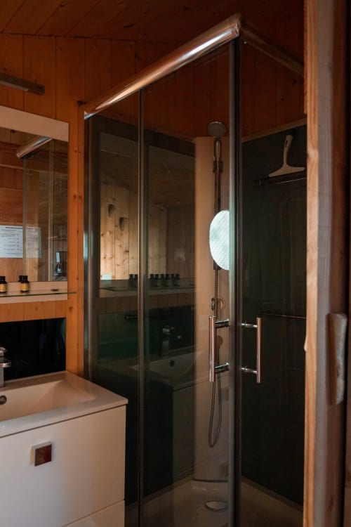 Modern glass shower enclosure in La Pinède villa bathroom at Cabanes et lodges du Belvédère, Serrières-sur-Ain