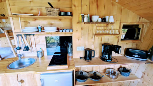 Angolo cottura in legno con elettrodomestici, stoviglie e scaffalature nella villa Cabane LA CHENAIE a Serrières-sur-Ain