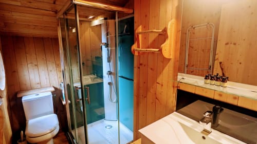 Bagno in legno con doccia, toilette e doppio lavabo presso Cabanes et lodges du Belvédère