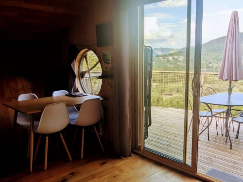 Villa moderna con sala da pranzo che si apre sulla terrazza con vista sulla valle e le montagne di Serrières-sur-Ain, con ombrellone