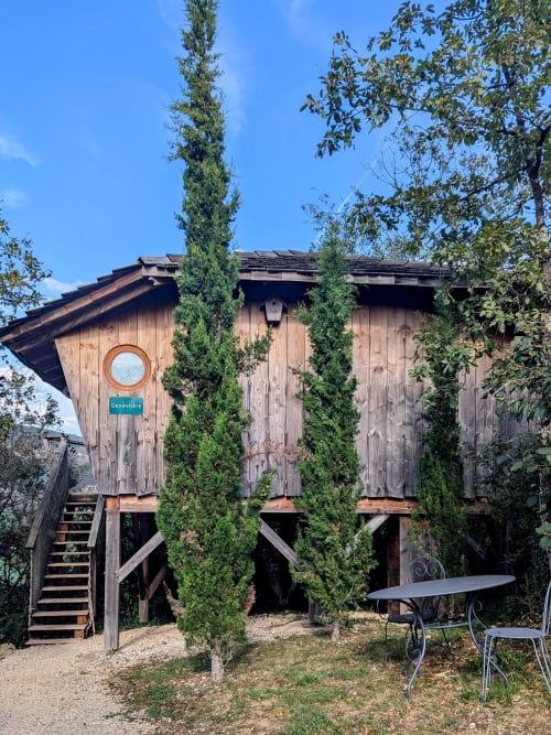 Capanna su alberi La Genevrière presso Cabanes et lodges du Belvédère a Serrières-sur-Ain, struttura in legno rialzata con edera