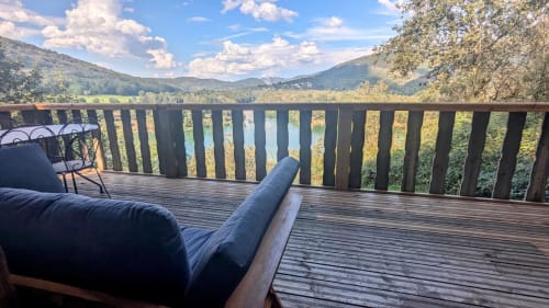 Terrazza in legno con lettino e balaustra che si affaccia sul fiume Ain e sulle montagne, villa Lodge LE BETET a Serrières-sur-Ain