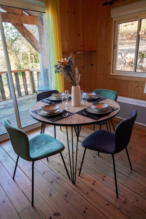 Area pranzo moderna nel Lodge LE TAILLET con tavolo rotondo, sedie in velluto e vista sul lago di montagna attraverso le grandi finestre
