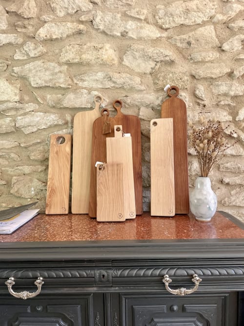 Planches à découper en bois exposées sur une étagère à la boutique-hôtel Le Mas F, Saint-Rémy-de-Provence