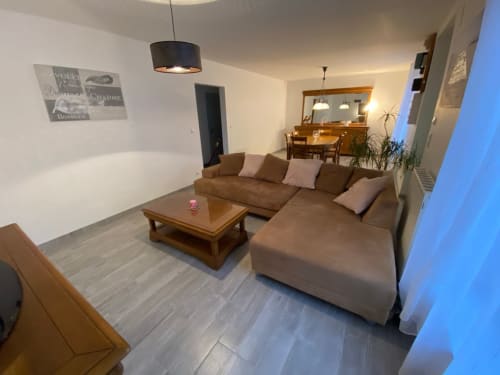 Spacious living room rental, holiday home with a cozy lounge, vacation rental with a fireplace, bright and airy living space, family-friendly holiday stay.