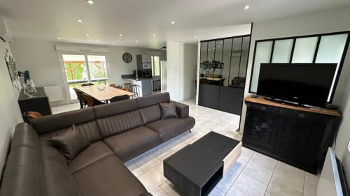 Spacious living room rental, holiday home with a cozy lounge, vacation rental with a fireplace, bright and airy living space, family-friendly holiday stay.
