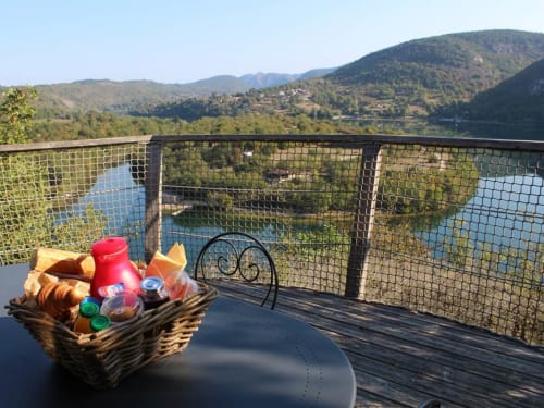 Panier de pique-nique sur la terrasse avec vue sur la vallée de l'Ain aux Cabanes et lodges du Belvédère, Serrières-sur-Ain