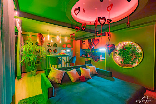 Espace détente moderne et coloré à L'Insolite Spa Privatif à Toulouse avec cœurs néon, mobilier vibrant et plantes
