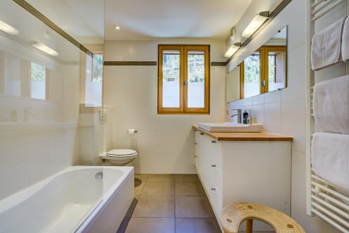 Bathroom with bath tub | Balcony Apartment – ​​Stunning View and Alpine Charm

